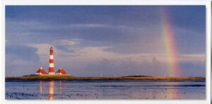 Ein Küstenpanorama - Westerheversand mit Leuchtturm und Regenbogen bei Westerheversand.