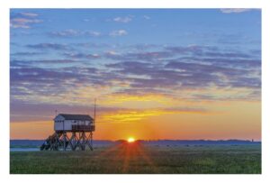 Ein kleines Gebäude liegt mitten im Küstenland – Es war ein schöner Tag am Strand von St. Peter-Ording.