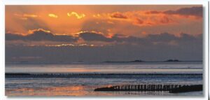 Der Nationalpark Wattenmeer - Farbenspiel - Die Sonne versinkt im Wolkenmeer geht unter und erzeugt ein wunderschönes Farbenspiel, während er in den Wolken versinkt.