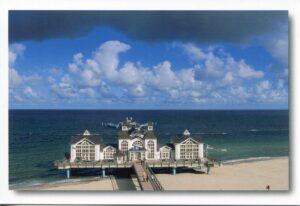 Ein Pier am Strand von Rügen - Meine Insel - Selliner Seebrücke mit Wolken am Himmel.