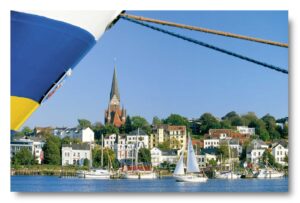 Ein Boot liegt im Hafen, im Hintergrund die Stadt Schleswig-Holstein - Hafen von Flensburg.