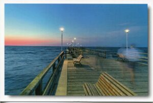 Eine Person sitzt auf einer Bank am Ende einer Seebrücke in Usedom – Meine Insel –.